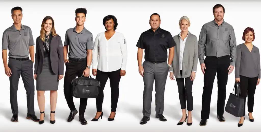 Diverse team wearing custom work uniforms and corporate branded apparel in a professional setting