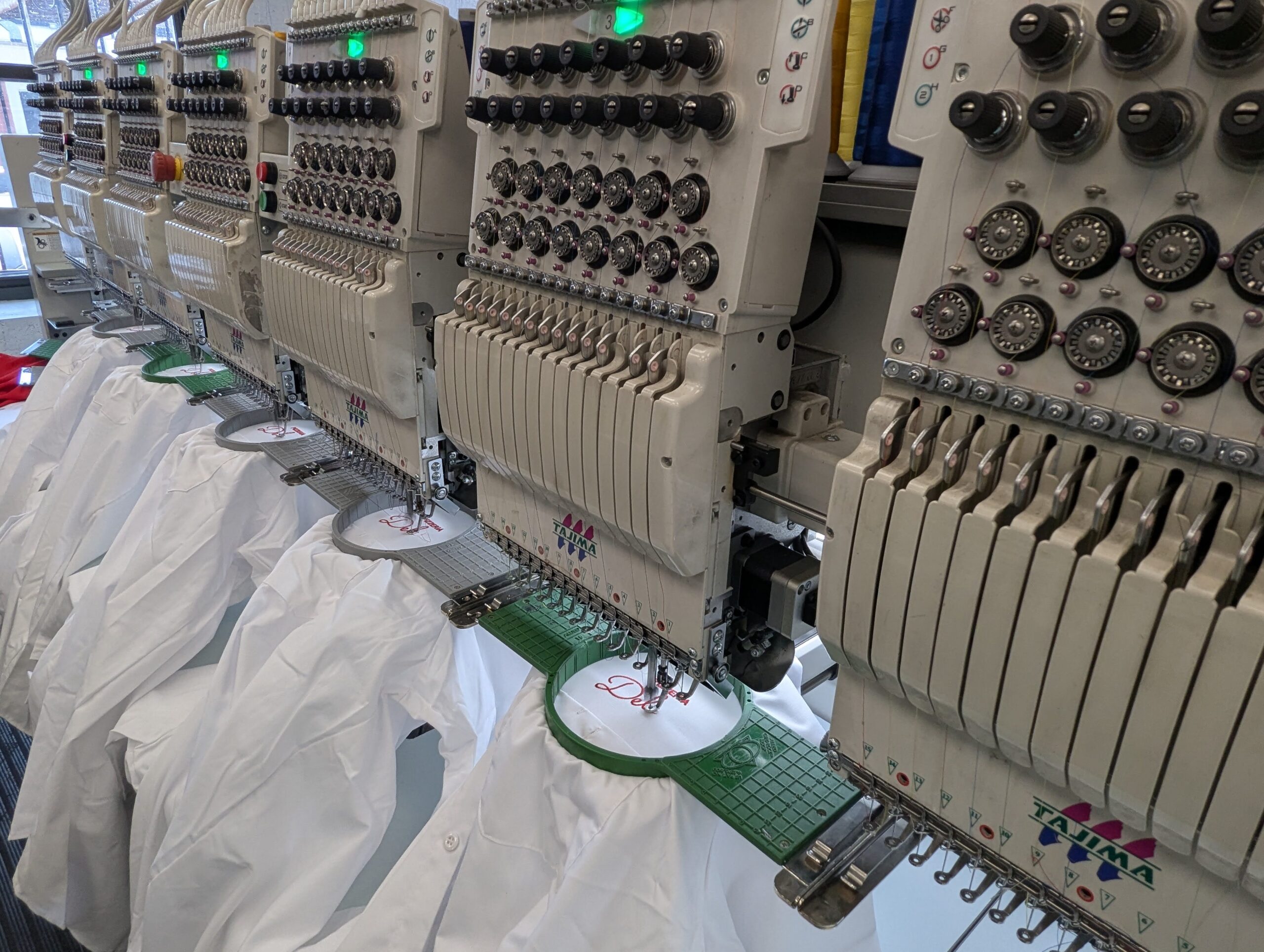 Multi-head commercial embroidery machines customizing branded work apparel