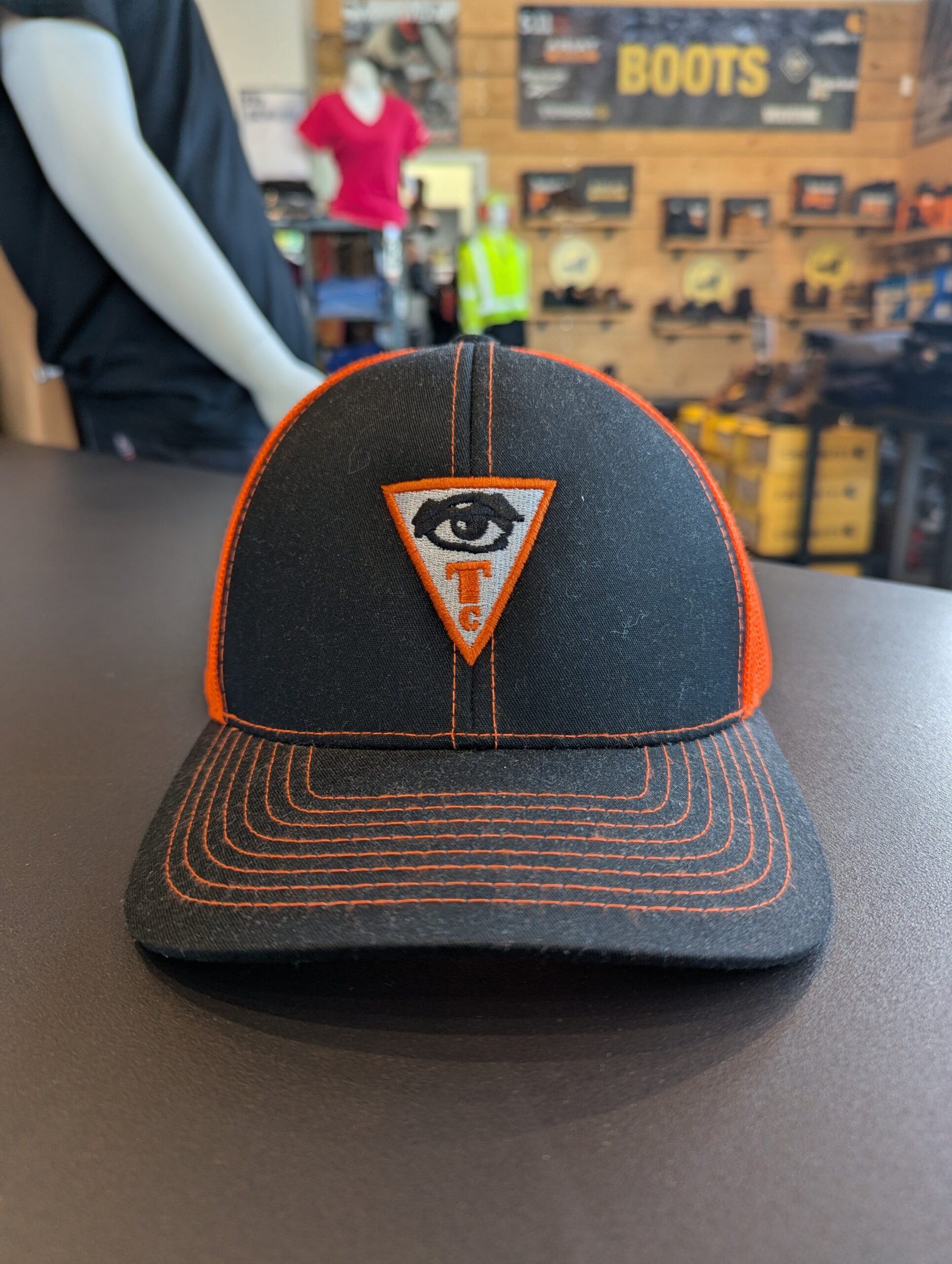 Black and orange work cap customized with an embroidered company logo