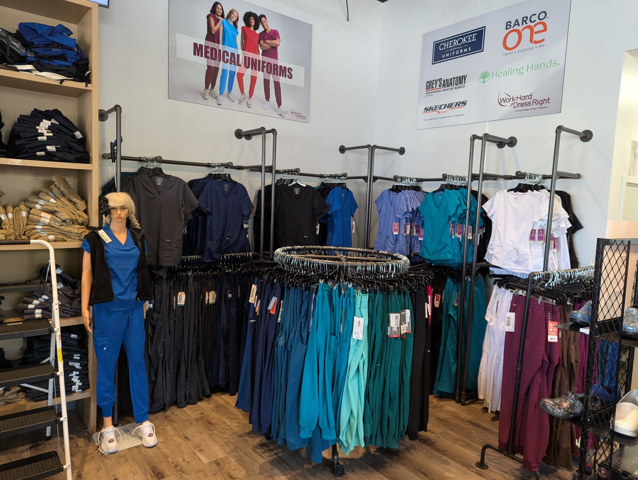 Racks of scrub tops and pants in multiple colors at the Newark store