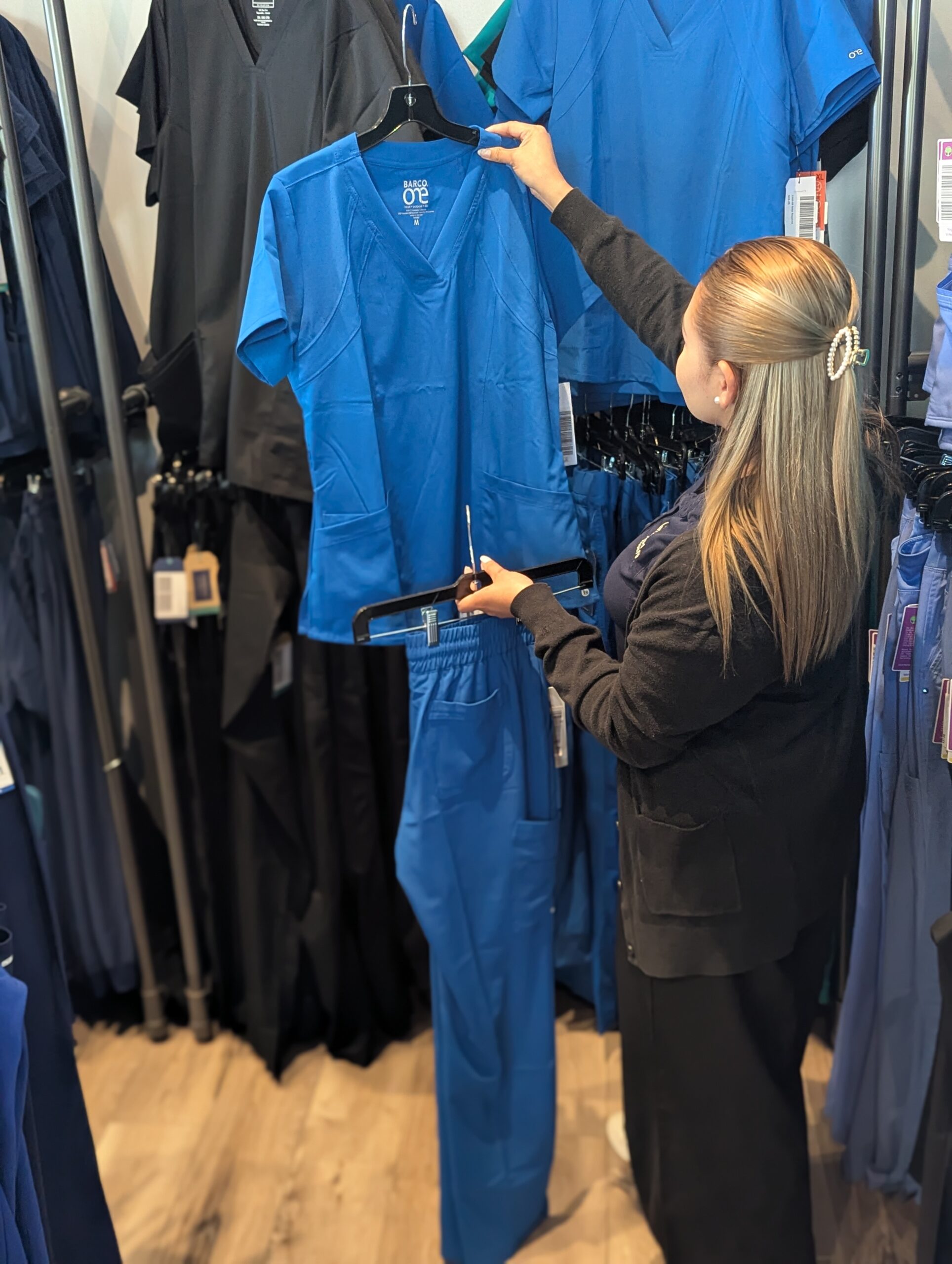 Customer shopping for blue scrubs at the Newark store